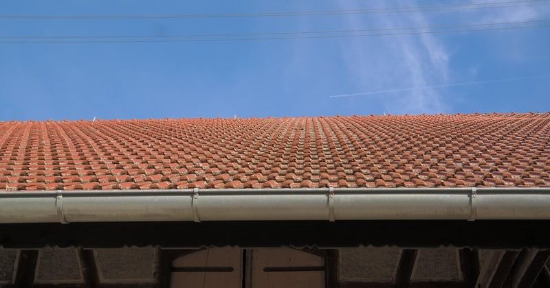 Comment poser une gouttière sur un toit en pente sans fuite : le guide